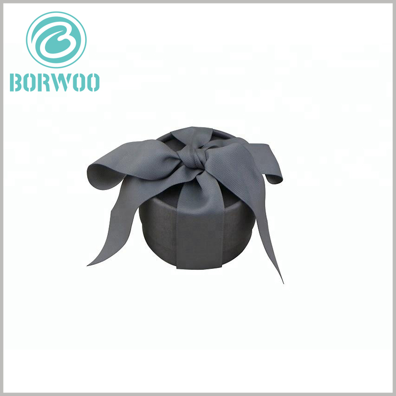 Grey cardboard tube round gift boxes with bows.