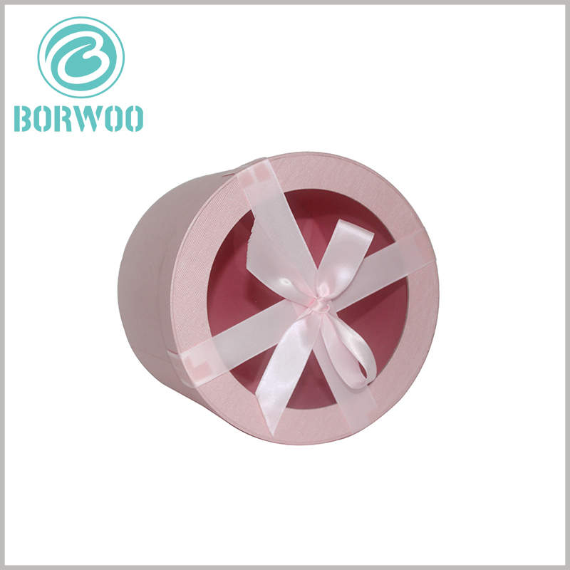 Pink round cardboard tubes gift packaging boxes with bows.a wide pink ribbon as decoration,More prominent the importance of gifts